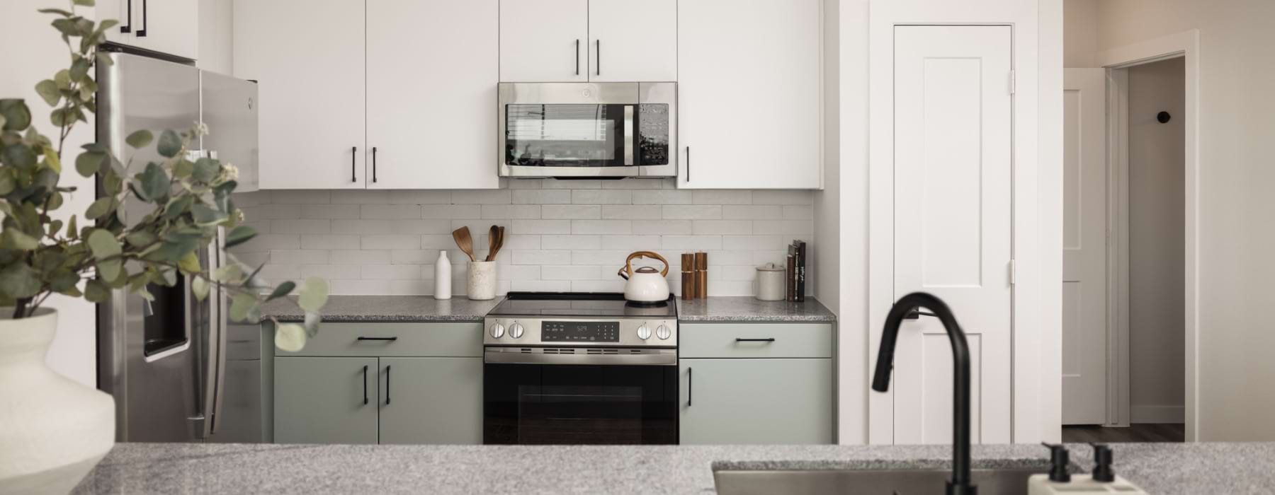 Light designer kitchen palette with countertops and tile backsplash at Odell Apartments