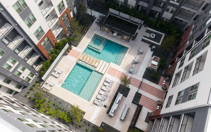 a courtyard with a pool and lounge chairs